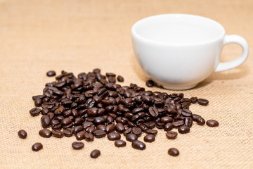 Cup of coffee with coffee beans on old background