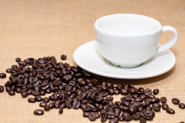 Cup of coffee with coffee beans on old background