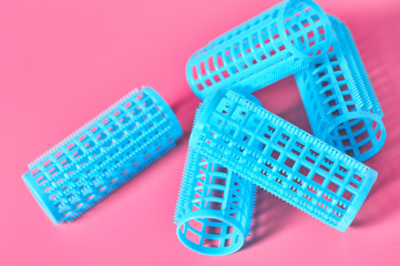 Heap of plastic cylindrical curler on pink desk in beauty salon. Care for hair. Fashion concept