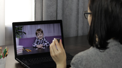 Woman teacher makes video call on laptop with children pupil. Distance education