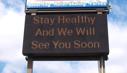 A hopeful sign at an American business closed as non-essential during the Coronavirus epidemic in the Spring of 2020 says Stay Healthy And We We Will See You Soon