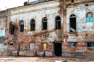 Old destroyed brick building with broken windows and rusty pipes. abandoned non-residential house....