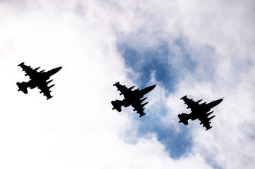 silhouettes of military aircraft in the sky with clouds at the parade. parade of military equipment. professional pilots perform tricks