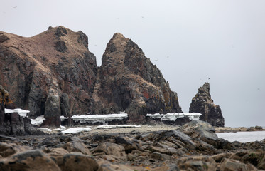 Rocky coast of the sea of Okhotsk on a cloudy spring day