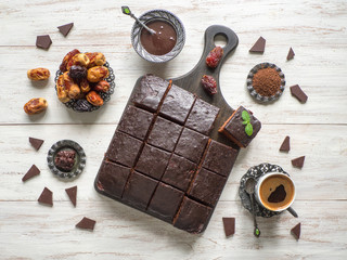 Chocolate brownie cake with dates, dessert on white wooden background