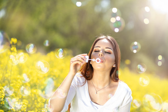 Young woman having fun with soap bubbles