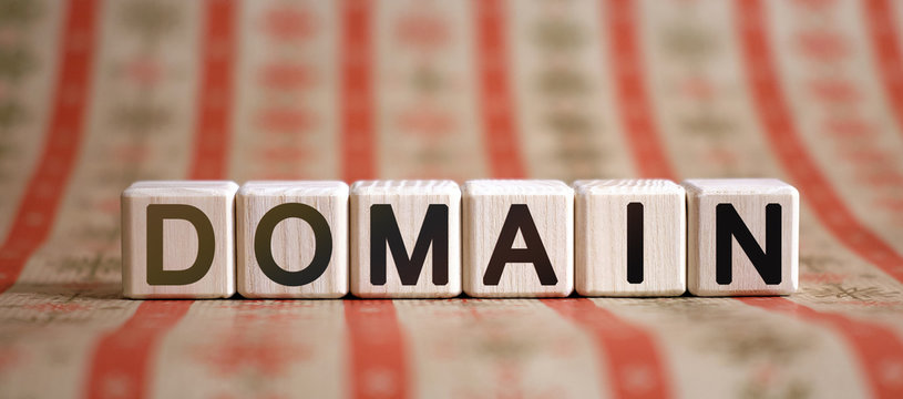 Domain - text concept on wooden cubes on a striped bright background