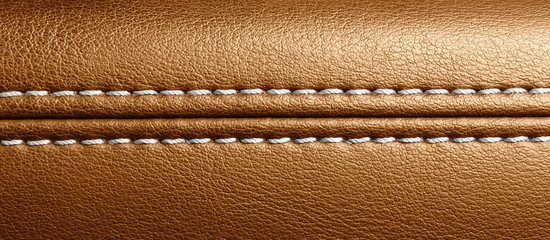 Car brown leather interior. Part of perforated leather door handle details. Orange Perforated...