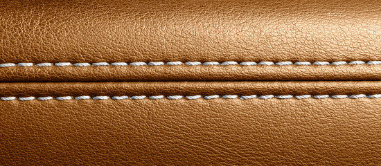 Car brown leather interior. Part of perforated leather door handle details. Orange Perforated...