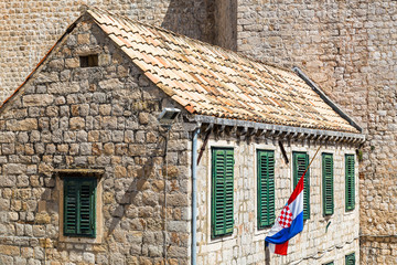 Croatian flag by a rustic building