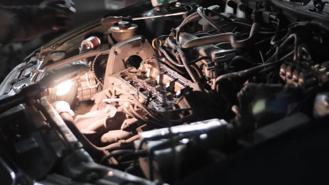 Man unmounting engine compensators at car service station