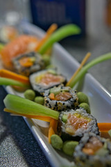 Freshly prepared homemade Salmon maki roll nicely decorated on a white plate