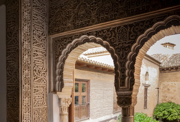 Detail of Islamic calligraphy on arches of the 14th century fortress complex of Alhambra, in medieval arabic style