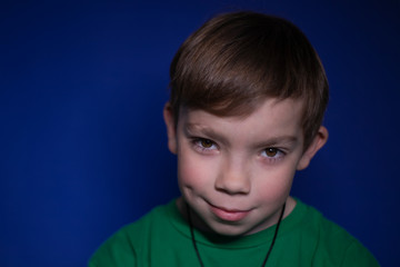 portrait of a nine year old blond boy on a blue background