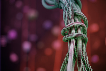 free climbing coiled up rope with dark blurred background - negative space for text