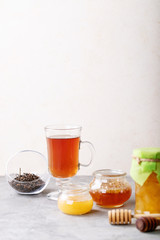 Glass cup of black tea served with honey
