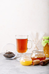 Glass cup of black tea served with honey