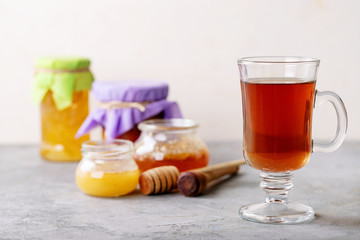 Glass cup of black tea served with honey