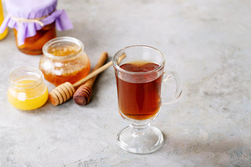 Glass cup of black tea served with honey