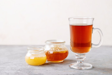 Glass cup of black tea served with honey