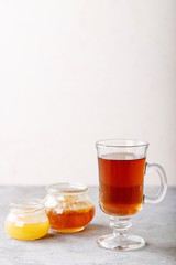Glass cup of black tea served with honey