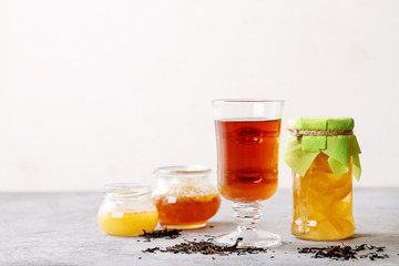 Glass cup of black tea served with honey