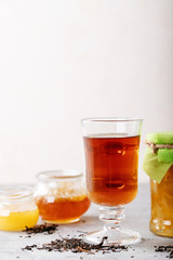 Fototapeta na wymiar Glass cup of black tea served with honey