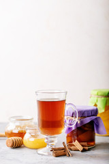 Glass cup of black tea served with honey