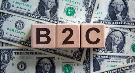 Concept word 'B2C' on cubes on a beautiful background from dollar bills.