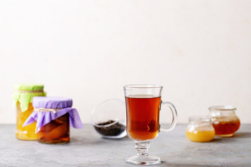 Glass cup of black tea served with honey