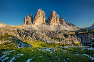 Tre Cime di Lavaredo Mountains with green grass, Dolomites Alps, Italy