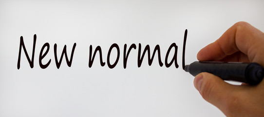 Hand writing 'new normal', isolated on beautiful white background. Concept.