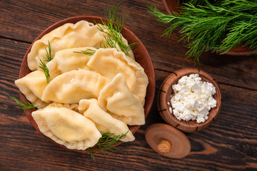 Homemade dumplings with sour cream and cottage cheese, green dill