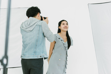 Asian Photographer shooting with female model in Studio on White background