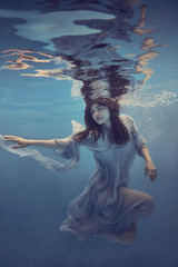 Portrait of a girl in a blue dress under water