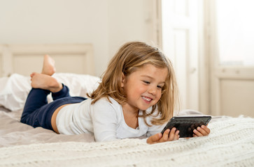 COVID-19 Lockdown. Little girl using mobile video calling or e-learning during coronavirus outbreak