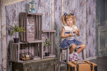 Portrait of little girl in retro vintage photographic studios.