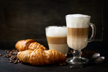 glasses of latte macchiato coffee and croissants