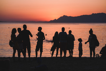 Fototapeta na wymiar Sylwetki ludzi na zachodzie słońca