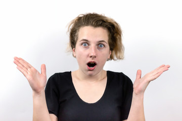 Close-up of a girl with an emotion of surprise with wide-open bright gray eyes, open mouth and raised hands. The concept of emotions.