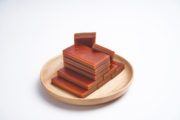 Tawny hawthorn cake in a wooden tray, isolated in a white background