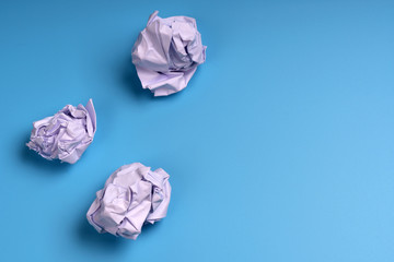 Crumpled balls of paper on a blue background