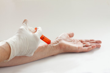 Close-up hands, nurses are vaccinations to patients in the under arm using the syringe. Doctor vaccinating woman. Studio shot with copy space. Selective focus.