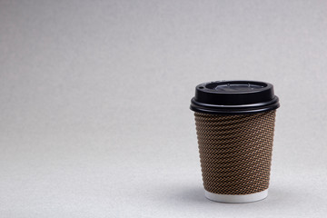 paper cup with coffee cappuccino on grey background Close up