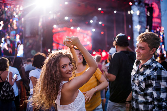 Rear View Of Group Of Young Friends Dancing At Summer Festival.