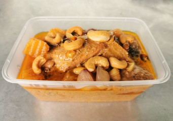 massaman curry chicken in plastic container for take away food. Massaman well known and popular Thai food.