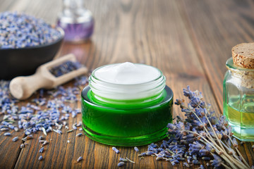 Natural lavender cream, bunch of dried lavender flowers, bottles of essential oil.