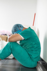 Tired doctor at the hospital. A doctor, a nurse who is thinking about treating a disease and a pandemic. Surgeon after surgery. Coronavirus, covid-19 concept