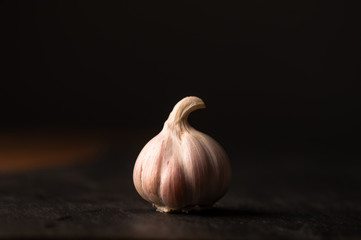 garlic on a grey slate with a  dark background 