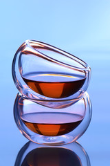 Two transparent tea glass cup with sunset background.
